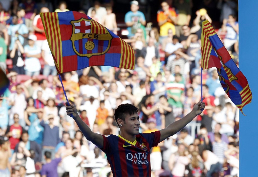 Neymar waves flags Barcelona's flags as he acknowledges the fans at his presentation after signing a five-year contract with the club, at Nou Camp stadium in Barcelona